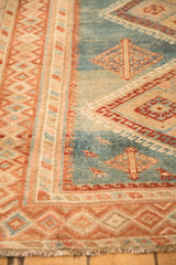 Close-up of the distressed pile and geometric border patterns on a vintage Persian Malayer rug.