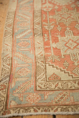 Detail of the worn low pile and geometric borders in terracotta, ivory, and powder blue.