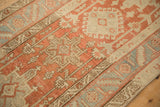 Detail of the Heriz runner's worn pile, showing Karaja medallions and a serrated leaf border.