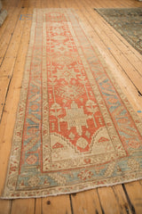 Angled view displaying the full length of a distressed Heriz runner with its traditional geometric design.