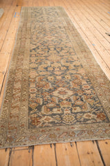 Long perspective of a distressed Malayer runner showing its dusty blue Herati pattern.
