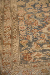 Low-pile texture and intricate starburst border on a vintage Malayer rug in dusty blue and rust.