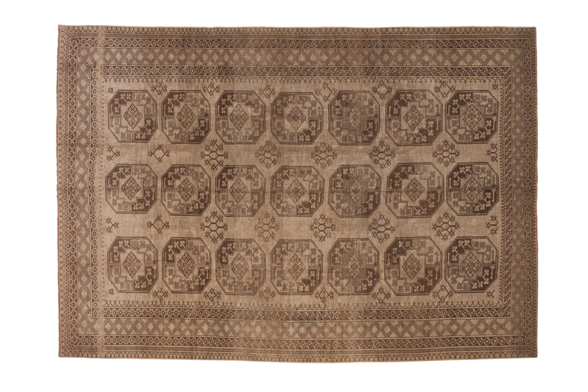 Vintage distressed Ersari carpet with repeating geometric guls in a monochromatic silver and charcoal palette.