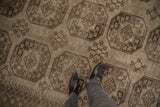 Close view of a distressed vintage Ersari carpet showcasing its low pile texture and charcoal geometric gul design.