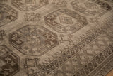 Worn, low-pile texture on the oversized guls and diamond border of a vintage Ersari carpet.