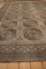 Angled perspective of a vintage Ersari carpet showing columns of charcoal geometric guls.