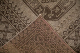 Corner view showing the hand-knotted back and low, even pile of a distressed vintage Ersari carpet.
