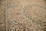 Angled view of a distressed Bakhtiari carpet highlighting its even wear and teal serrated leaf design.