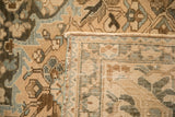 Folded corner of a distressed Bakhtiari rug showing the hand-knotted foundation and secured side cord.
