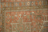A vintage Persian Karaja rug's corner with a geometric floral border in slate blue and ruby red.