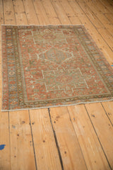 Angled view of a distressed Persian Karaja rug, showcasing its time-softened patina and geometric design.