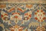 Detail of interconnected floral buds with serrated leaves on a distressed Malayer rug's low pile.