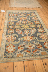 Full perspective view of a distressed Malayer rug highlighting its colorful geometric floral pattern.
