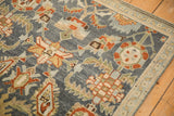 Expressive serrated leaves and checkered floral motifs on a distressed vintage Malayer rug corner.