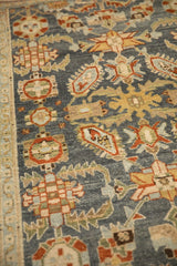 Angled view of a vintage Malayer's interconnected floral buds on a distressed deep blue pile.