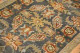 Detailed close-up of a distressed Malayer rug's low pile with serrated leaves and checkered florals.