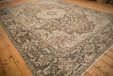 Angled view of a vintage Heriz carpet with its complex geometric medallion and vine pattern.