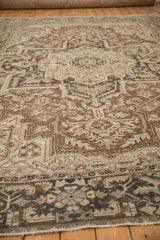 Angled view of the distressed low pile and geometric patterns on a vintage Heriz rug.