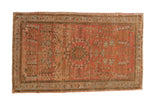 Vintage distressed Sarouk rug with a floral shadow medallion on a dusty blush field with a powder blue border.