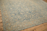 Softly worn texture on a vintage Tabriz carpet in sky blue and sand floral patterns.