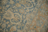 Low-pile texture and meandering vine border on a distressed vintage Persian Tabriz carpet.