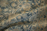 Hand-knotted texture of a distressed Tabriz carpet with scrolling floral vines in blue and sand.