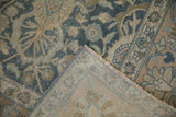 Corner of the distressed vintage Tabriz carpet folded to reveal its hand-knotted foundation.