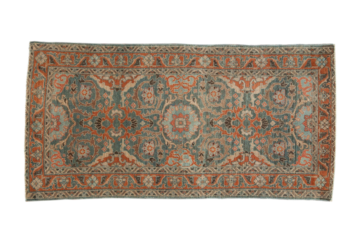 Vintage distressed Malayer rug with a central floral medallion and scrolling vines in sky blue, red, and silver tones.