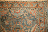 Corner view of a vintage Malayer rug highlighting the arabesque border and intact side cord selvage.