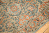 Detail of the arabesque leaf border and worn texture on a vintage Persian Malayer rug.