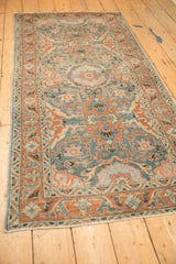 Angled view of the vintage Malayer runner's allover floral pattern in sky blue, red, and silver tones.