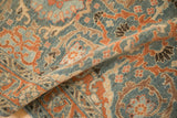 A soft fold reveals the distressed texture and hand-knotted arabesque pattern of the Malayer rug.
