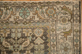 Geometric floral border and distressed low pile on the corner of a vintage Hamadan rug.