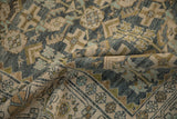 A fold in the distressed rug reveals even wear to the knot heads in dusty teal and moss green.