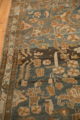 Angled view showing the narrow vine border and expressive wear of a Malayer rug runner.