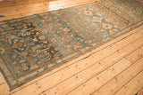 Angled view of a distressed Malayer runner showing significant color abrash and a low, even pile.
