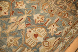 Artistic floral rendering with scrolled leaves on the low, textured pile of a vintage rug.