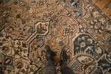 Low pile and decorative wear on a Bakhtiari carpet with floral motifs in dusty blue and brown.