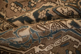 A folded view of the vintage Bakhtiari showing its textured pile in dusty blue and coffee brown.