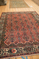 Low angle view of the vintage Malayer rug, showing its intricate brick red floral and geometric field.