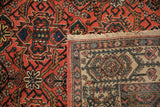 The reverse weave and hand-knotted construction of a vintage Persian Malayer rug's folded corner.