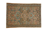 Vintage distressed Mehreban rug with a central floral paisley motif in dusty teal, blush, and rose tones.