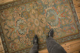 Distressed vintage Mehreban rug with dusty teal and blush florals, viewed on the floor for scale.