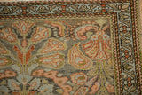 Corner view of a vintage Mehreban rug's meandering vine border and expressive floral blossoms.