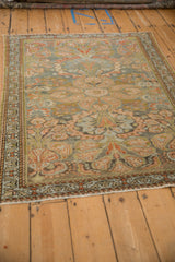 Angled view of a vintage Mehreban rug showing its meandering floral pattern and soft, distressed patina.