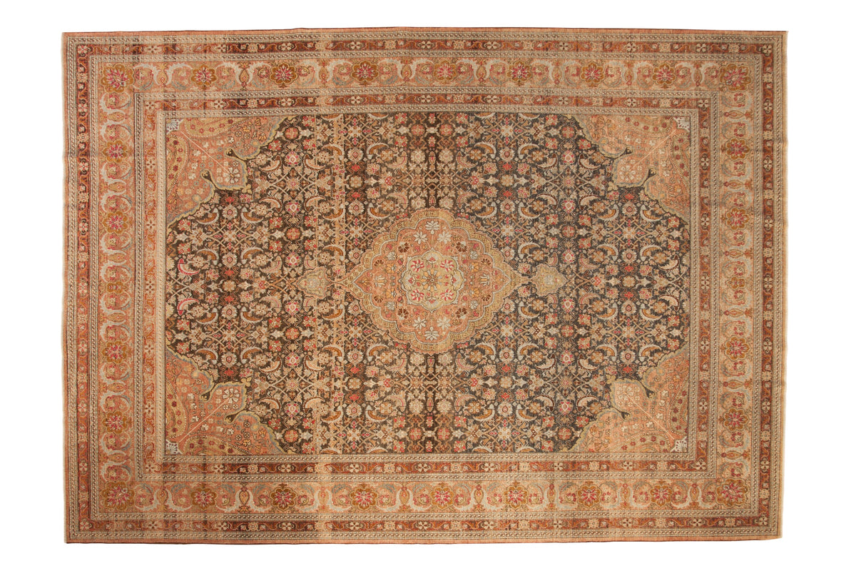 Distressed vintage Sivas carpet with a central medallion, charcoal Herati design, and warm blush tones.
