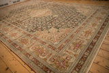 Corner of a vintage Sivas carpet with dusty blush spandrels over a detailed charcoal field.