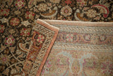 A folded corner on the vintage Sivas carpet reveals its hand-knotted back and dark pile.