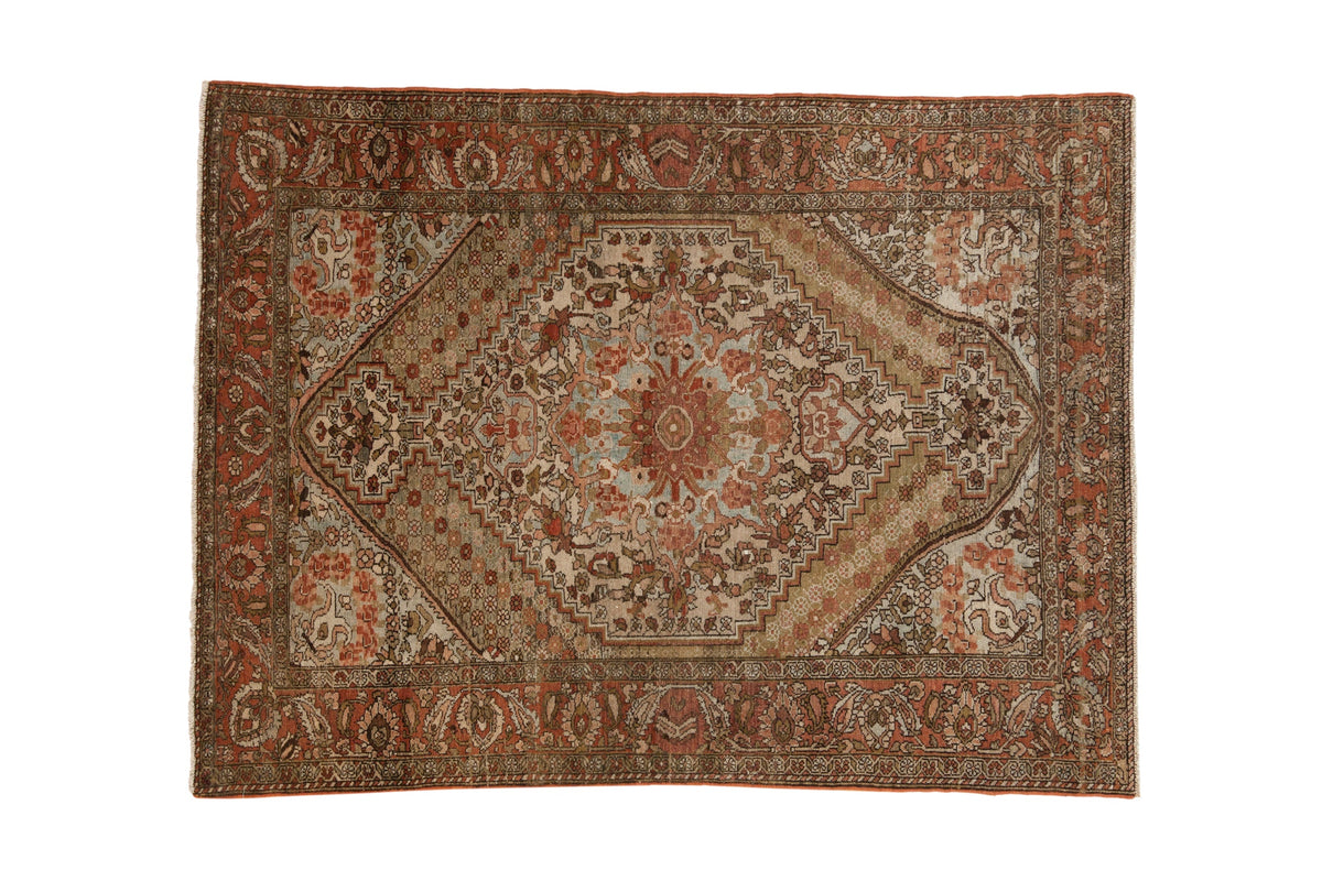 Vintage distressed Persian Bakhtiari rug with a central stepped medallion in brick red, ivory, and powder blue.