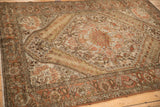 Angled perspective on a distressed Bakhtiari rug's paisley boteh border and stepped medallion detail.